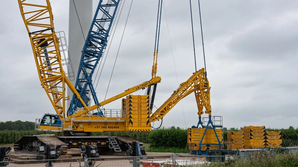A 60-ton crawler crane lifting a steel girder on a Hokkaido winter jobsite